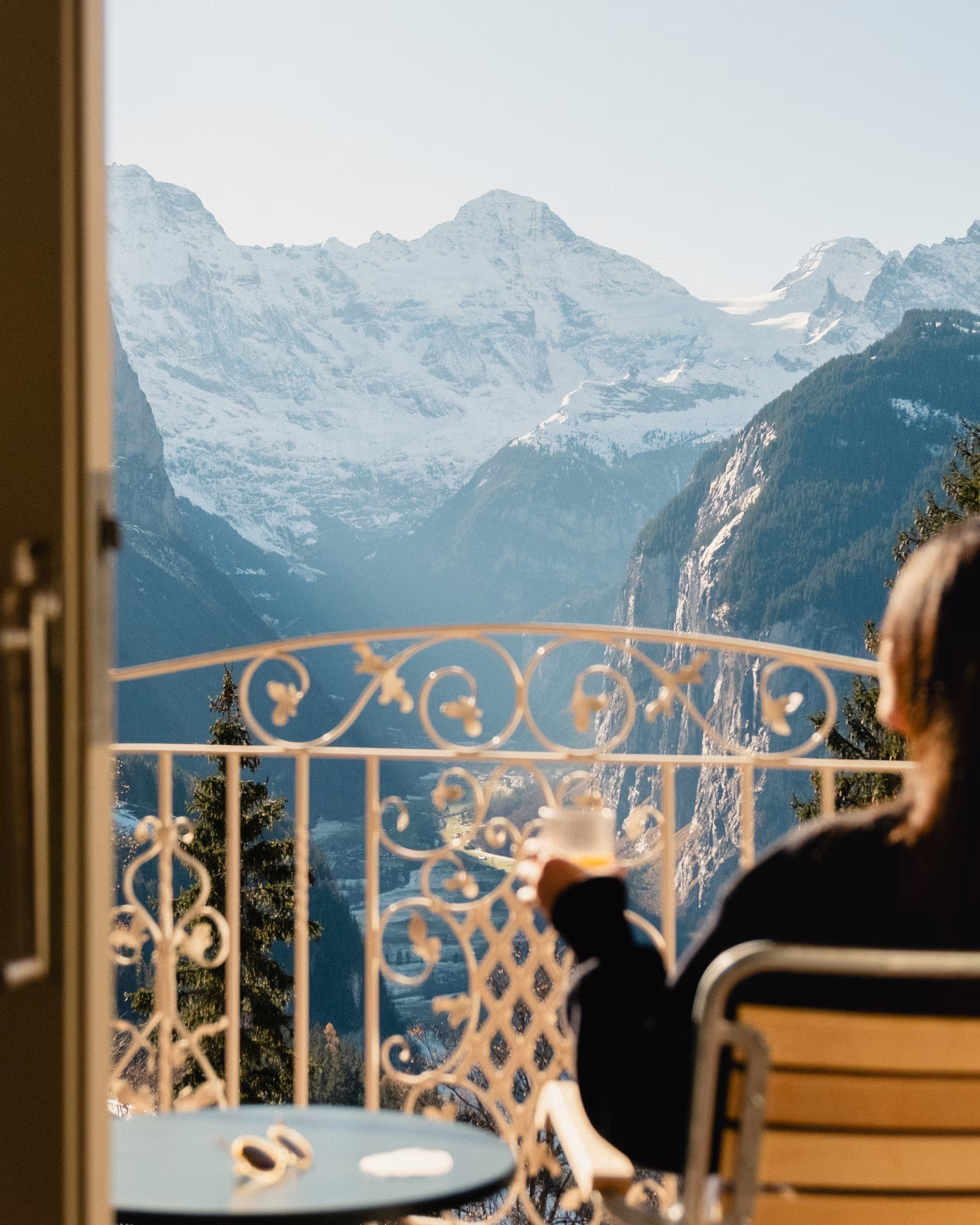 A guest looking across the Lauterbrunnen valley from a Grand Hotel Belvedere balcony.