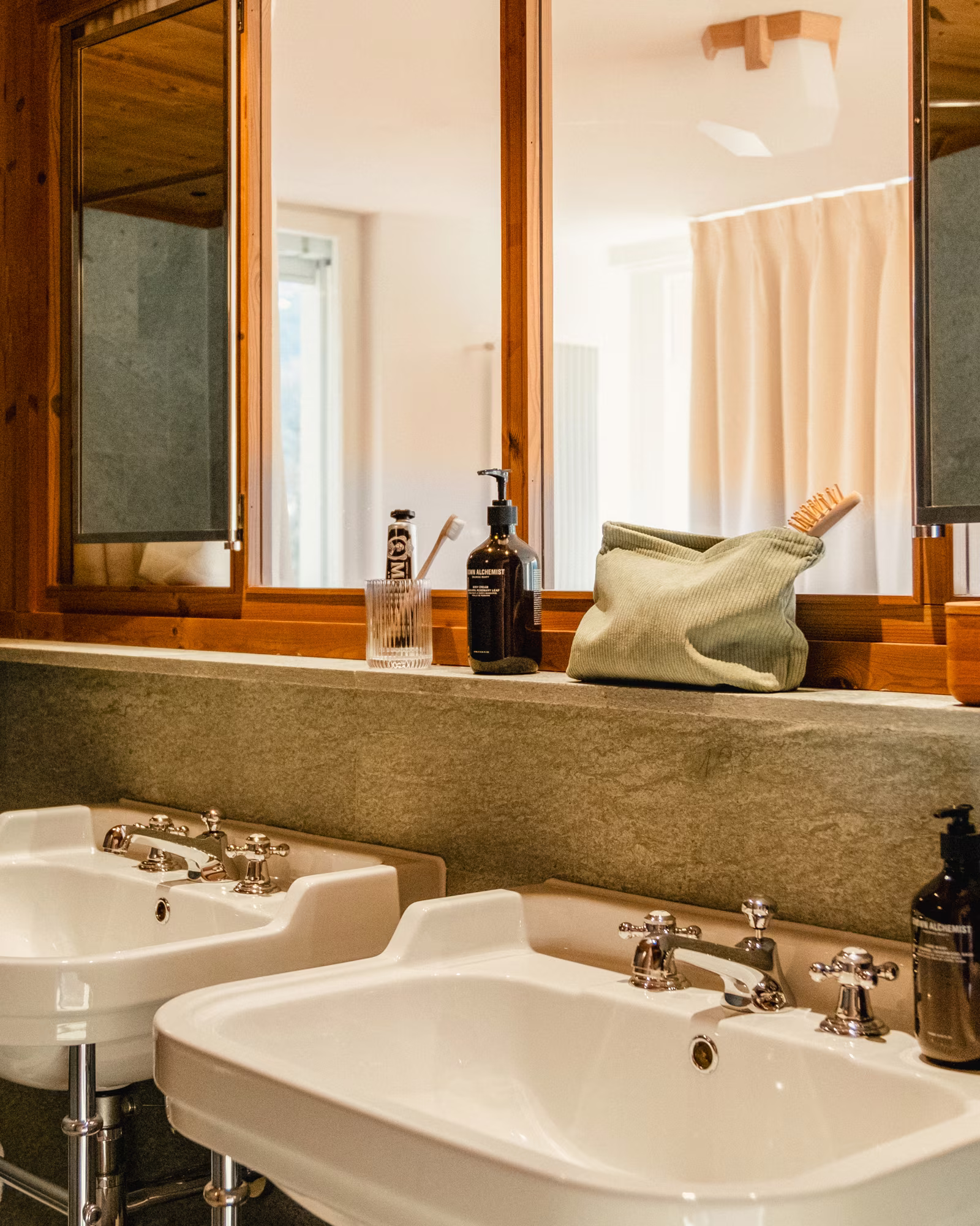 A Grand Hotel Belvedere bathroom with twin basins and warm timber detailing.