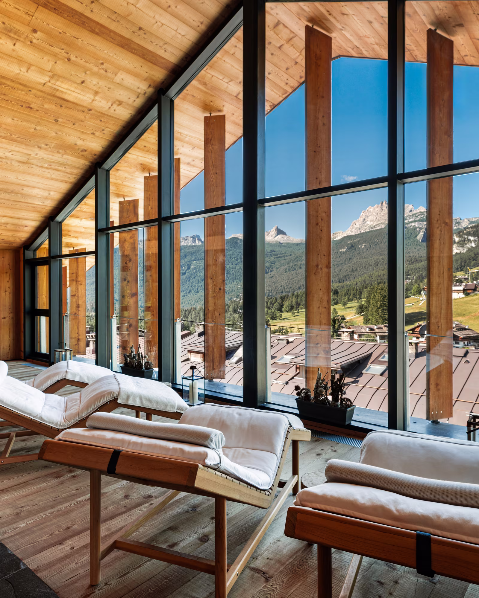 Timber-roofed spa lounge with panoramic windows over Cortina.