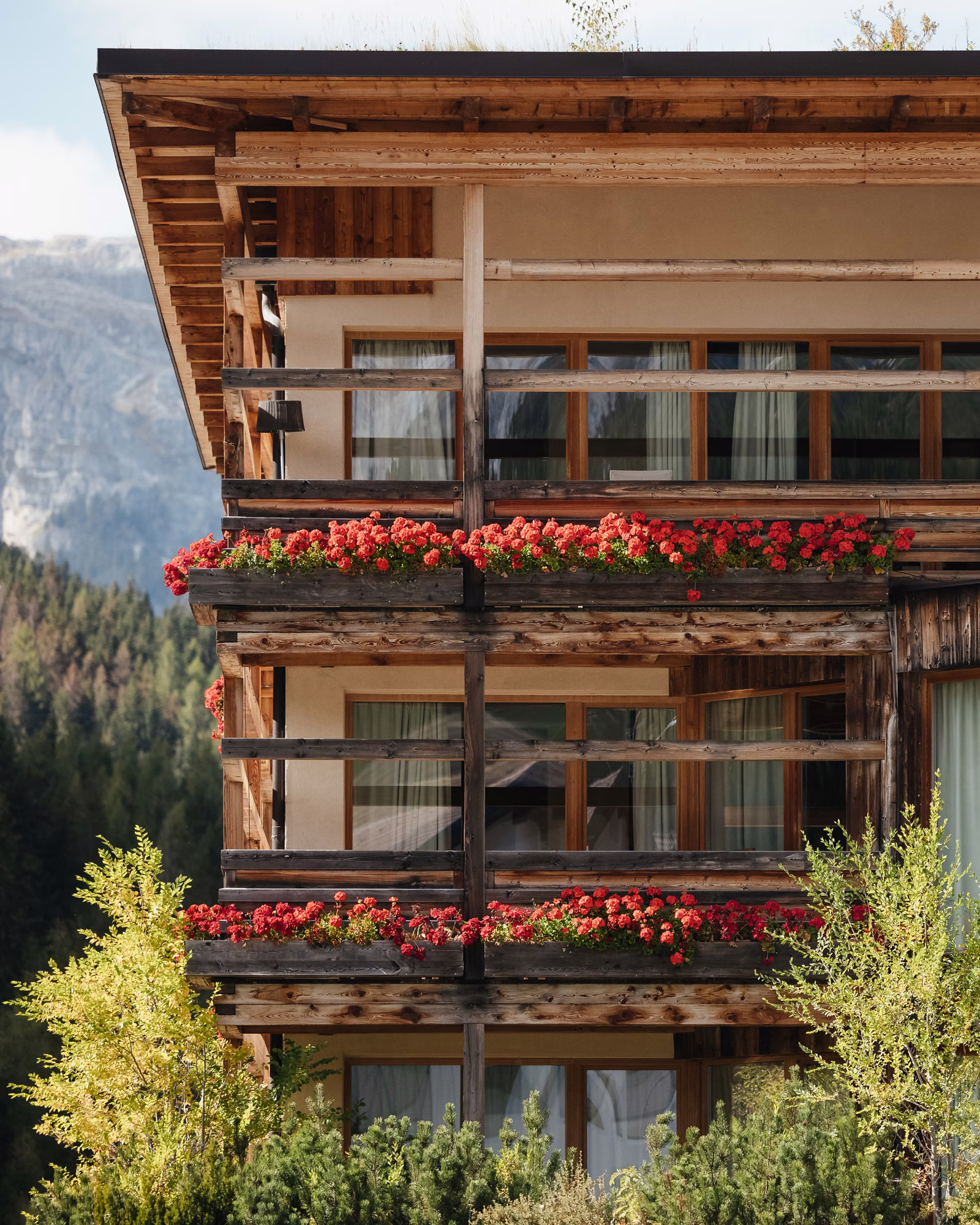 Timber façade and flower-lined balconies at Lagació