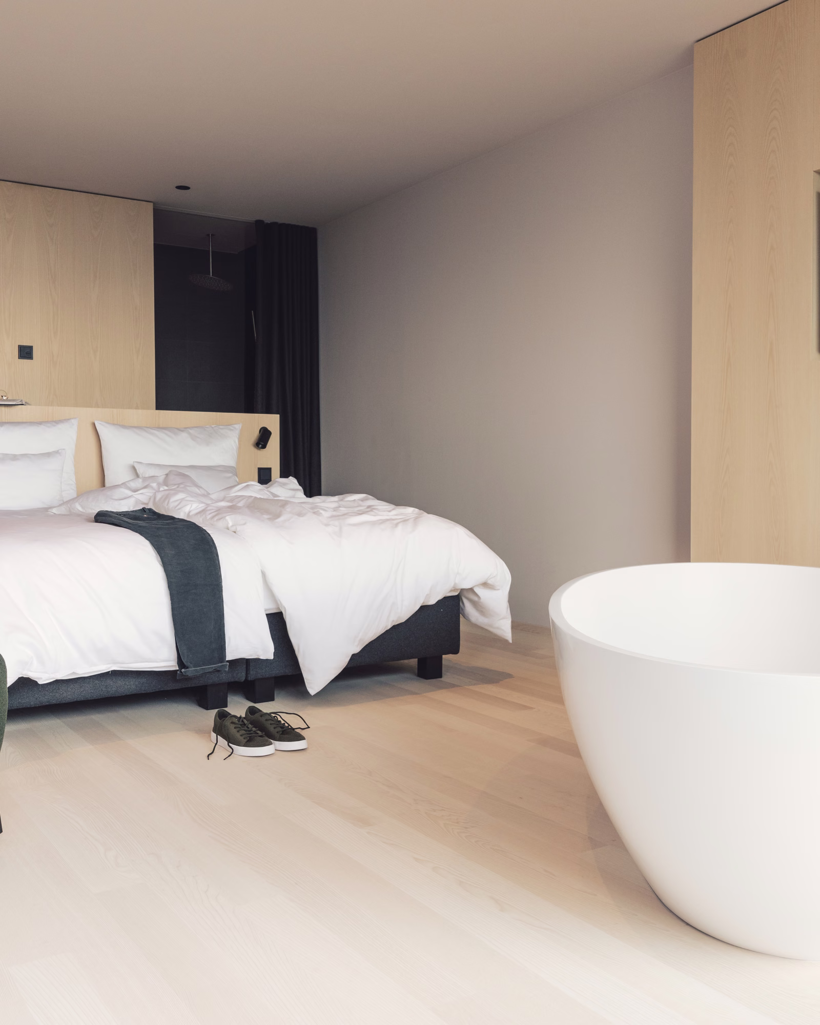 Pale timber guest room with a freestanding bath at Milla Montis