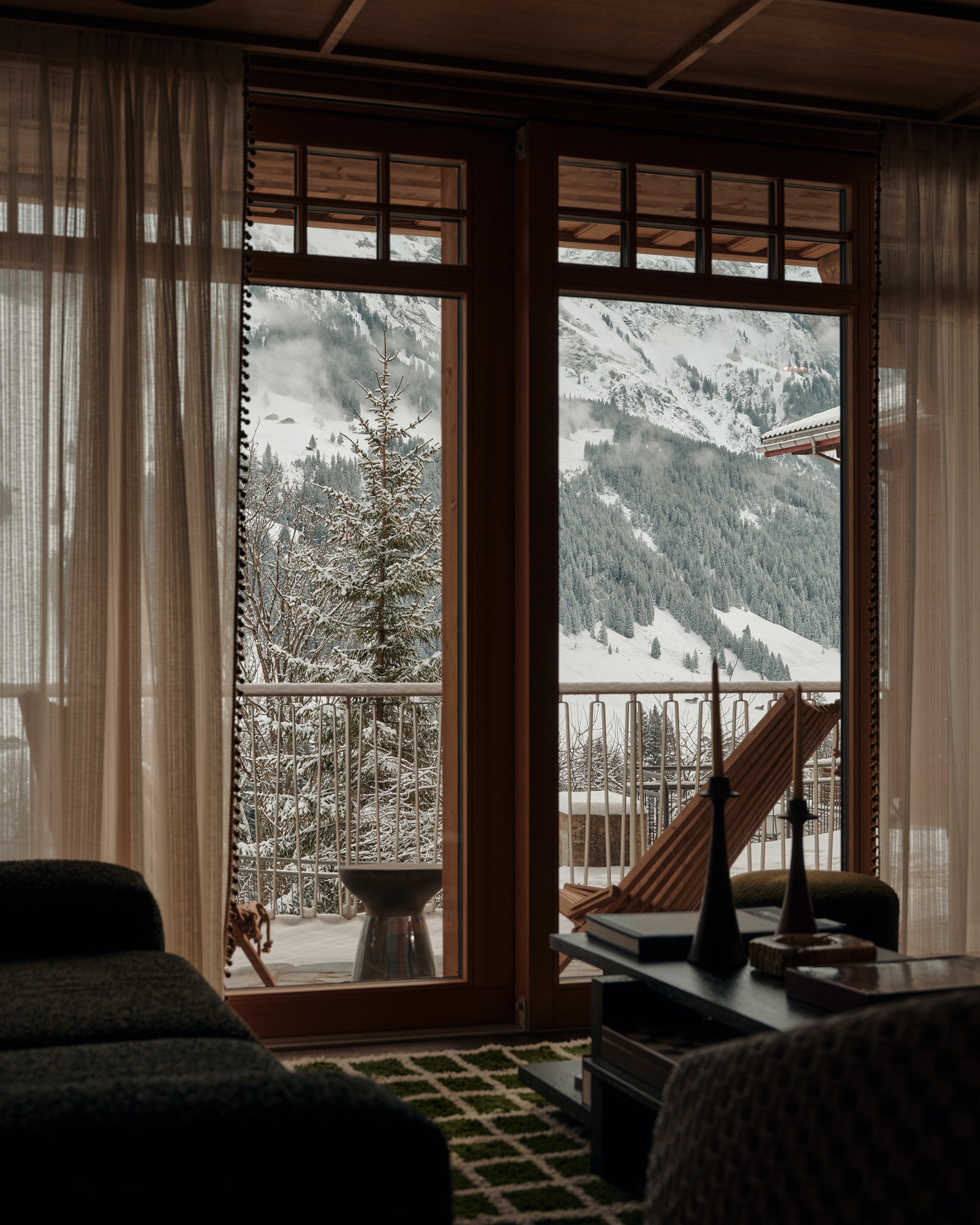 A snowy mountain view through The Brecon's lounge windows.